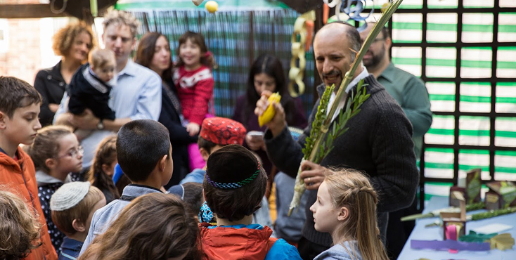 Sukkot festival. Masorti Rabbi surrounding by children.