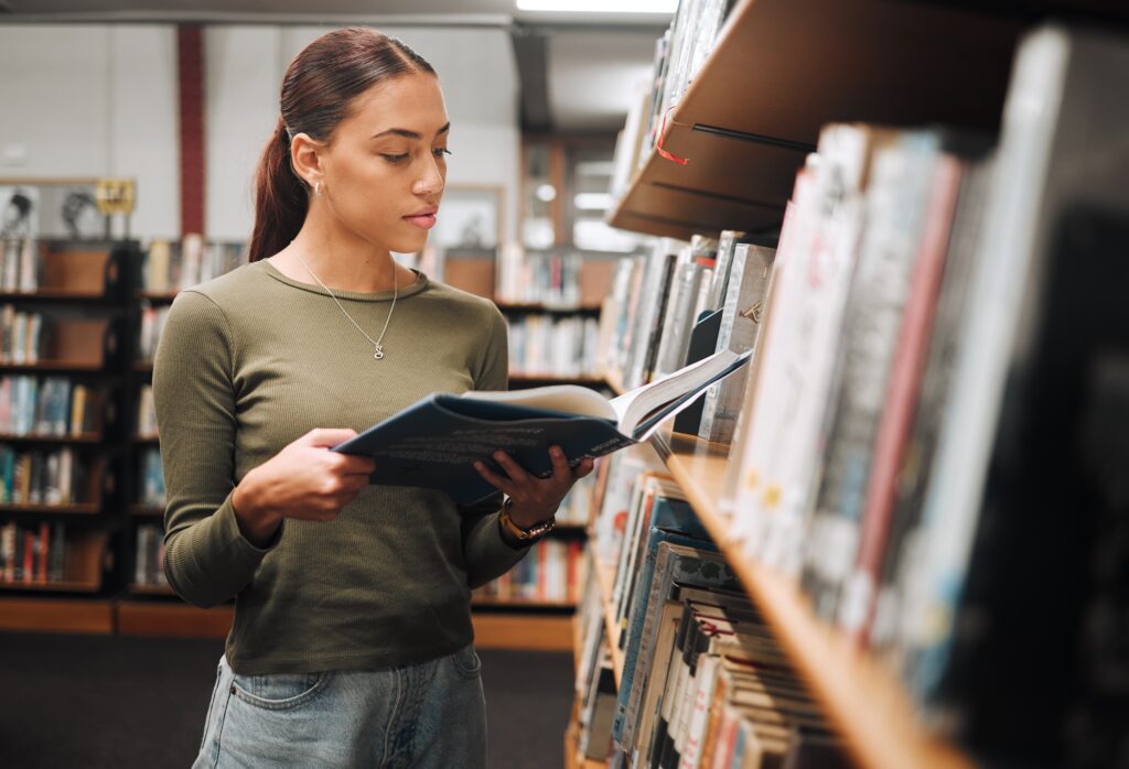 Young woman reading a book in a library. Photo ©PeopleImages.com - Yuri A / Shutterstock.com